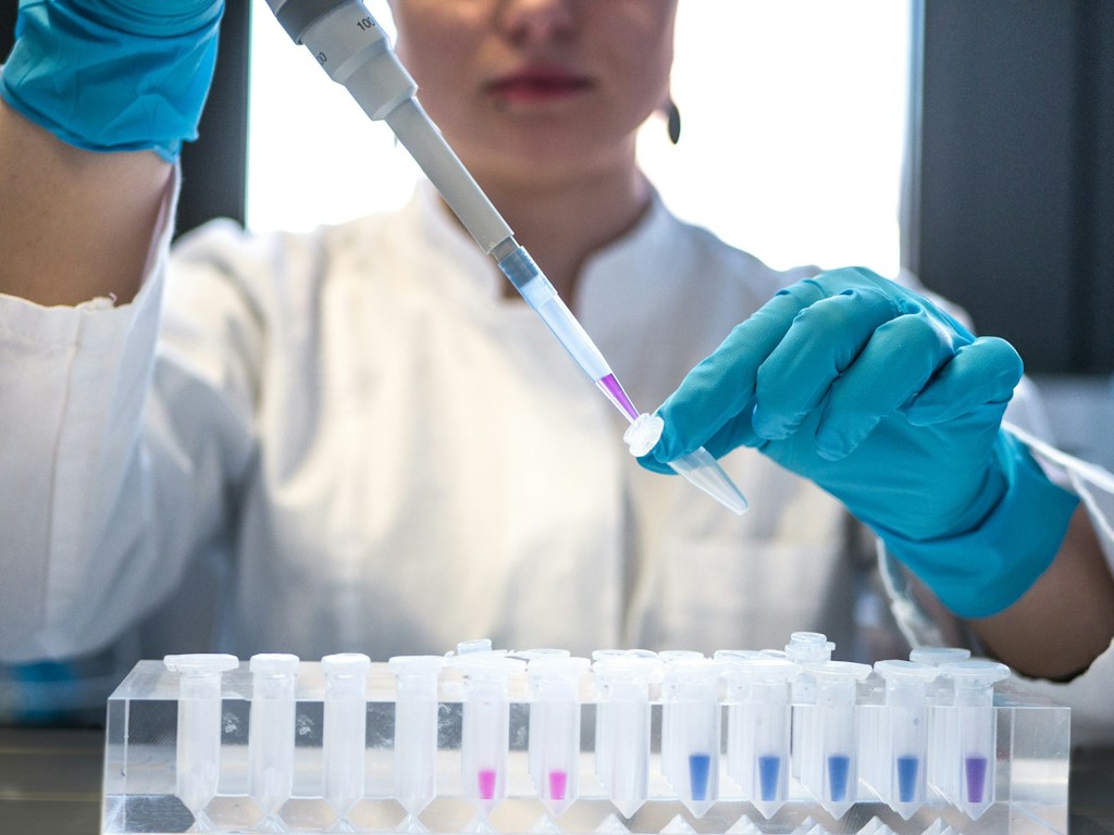 A laboratory researcher handling samples, illustrating the clinical research required to evaluate experimental psychiatric treatments.