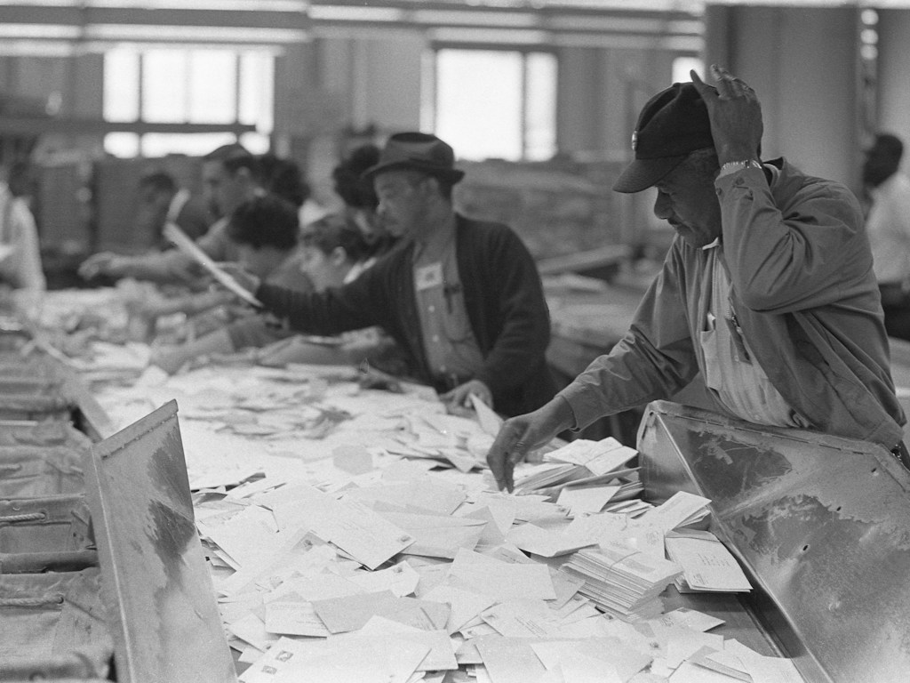 Archival photograph of postal workers sorting mail, illustrating general mail handling rather than the California ballot count.