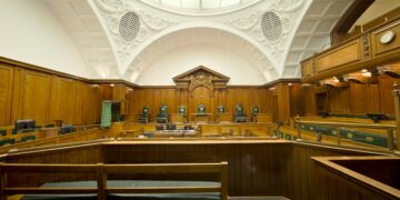 Empty modern courtroom with wooden judicial benches; illustrative image for reporting on a Dubai Court of Appeal judgment.