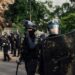 Riot police officers holding shields in an urban street, used as contextual imagery for France's recent unrest.