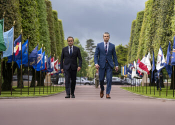 French Prime Minister Sébastien Lecornu walking alongside U.S. Defense Secretary Pete Hegseth during a ceremony in Normandy in June 2025.