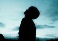 Silhouette of a child looking up at an evening sky.