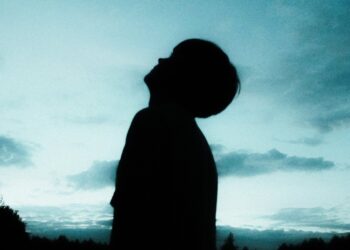 Silhouette of a child looking up at an evening sky.