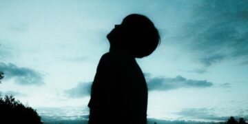 Silhouette of a child looking up at an evening sky.
