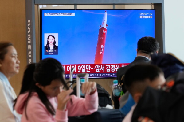 Commuters at Seoul Railway Station watch a television showing a North Korean missile launch report on October 12, 2026