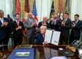 President Donald Trump holds up the signed executive order on accelerating medical treatments for serious mental illness at the White House on April 18, 2026.
