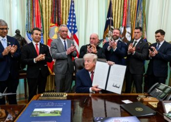 President Donald Trump holds up the signed executive order on accelerating medical treatments for serious mental illness at the White House on April 18, 2026.