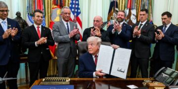 President Donald Trump holds up the signed executive order on accelerating medical treatments for serious mental illness at the White House on April 18, 2026.